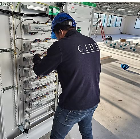 Technicien CIDE Électricien câblant un tableau électrique sur chantier