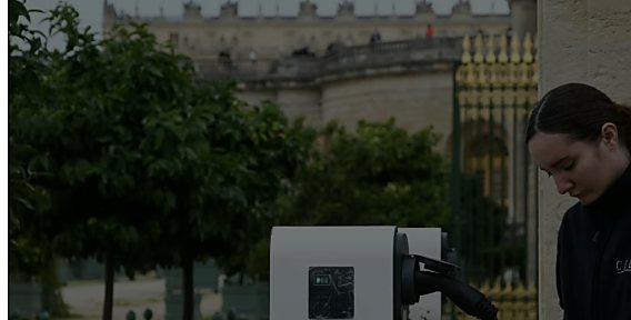 Technicienne CIDE branchant un véhicule sur une borne de recharge