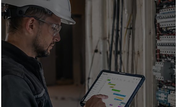 Électricien CIDE utilisant une tablette sur un chantier